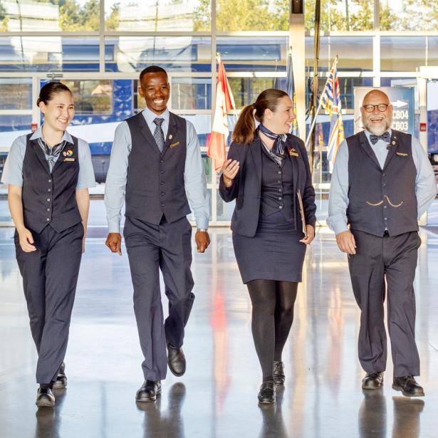 A group of hosts walks together through the station, ready to assist guests.